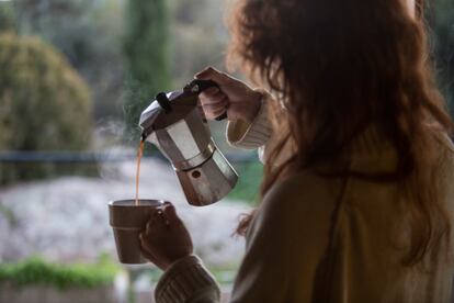 Una mujer se sirve una taza de café.