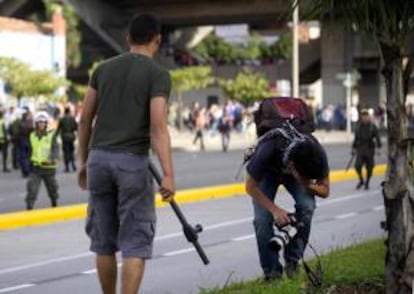 El fotógrafo de Agencia Efe Luis Eduardo Noriega (d) recibe un golpe de un policía vestido de civil (i) el 29 de agosto de 2013, en Medellín (Colombia).