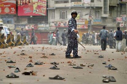 Hasta ahora, todas las grandes manifestaciones planeadas por la oposición en Nepal han sido abortadas debido a los toques de queda y otras medidas restrictivas de las libertades adoptadas por las autoridades nepalíes. Un policía vigila una calle llena de zapatos y piedras, objetos lanzados por los manifestantes.