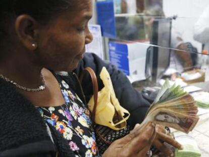 Una mujer cambia bol&iacute;vares por d&oacute;lares en una casa de moneda en Caracas, el pasado febrero. 