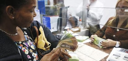 Uma mulher troca bolívares por dólares em Caracas, em fevereiro.