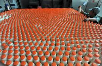 Un trabajador inspecciona las botellas que llegan al final de la cadena de producción de una compañía lechera. EFE/Archivo