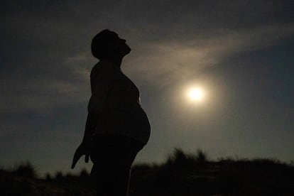 Una mujer embarazada, a la luz de la Luna