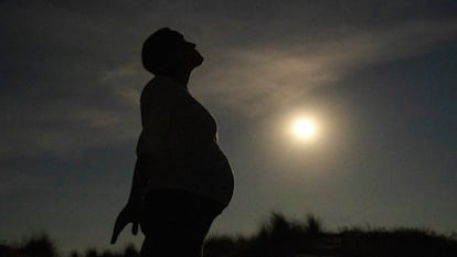 Una mujer embarazada, a la luz de la Luna.