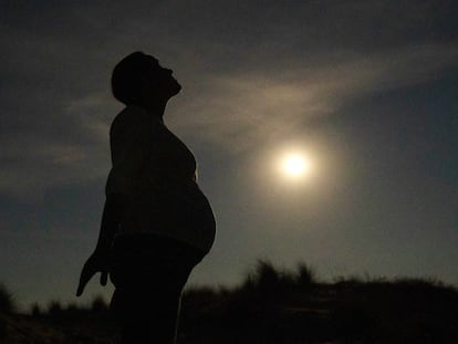 Una mujer embarazada, a la luz de la Luna.