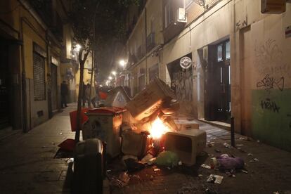 Contenedores incendiados en la calle Mesón de Paredes con la calle del Oso, en el barrio de Lavapiés de Madrid.