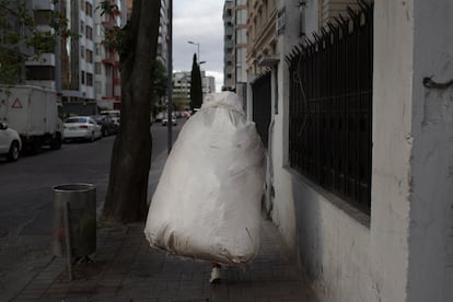 La recicladora Elizabeth Pulupa carga por las calles de Quito un saco lleno de basura hasta el camión, en agosto de 2019. 