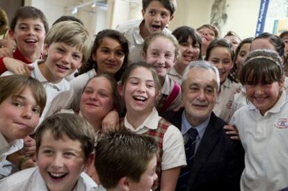 El presidente de la Junta de Andalucía, José Antonio Griñán, posa en Sevilla para la foto con un grupo de escolares ganadores de los premios de cartografía Andalucía en un Mapa.