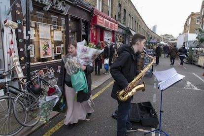 Oliver, un joven músico, toca en Columbia Road, en Londres.