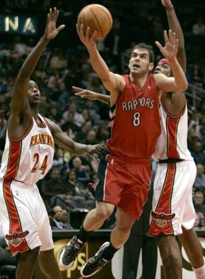 El base José Manuel Calderón entra a canasta ante la presencia de los jugadores de los Hawks de Altlanta Marvin Williams y  Josh Smith.