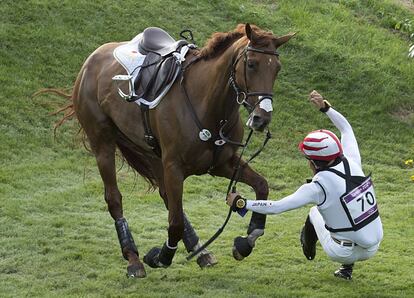 El japonés Yoshiaki Oiwa sufre una caída de su caballo, durante la prueba de concurso completo.