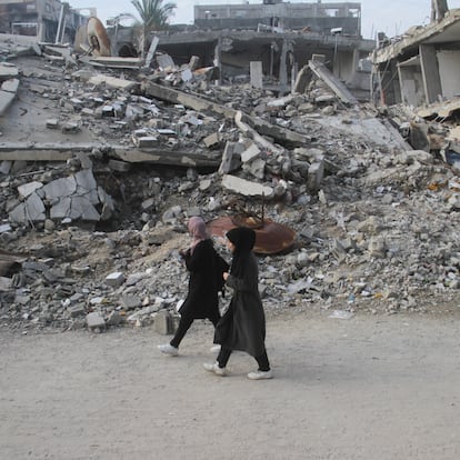 Palestinian women walk past the rubble of buildings destroyed in previous Israeli strikes, ahead of a ceasefire set to take effect on Sunday, in Gaza City January 16, 2025. REUTERS/Mahmoud Issa