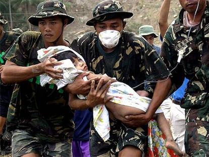 Soldados filipinos rescatan a una niña atrapada entre los escombros en Tigloan, al norte del país.