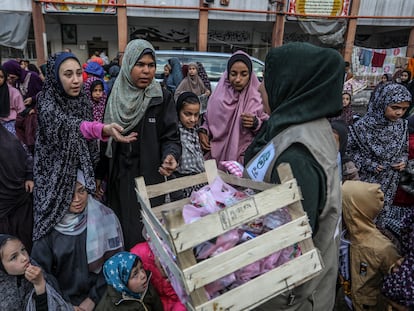 An aid worker distributes sweets among women and girls in Rafah, April 10.