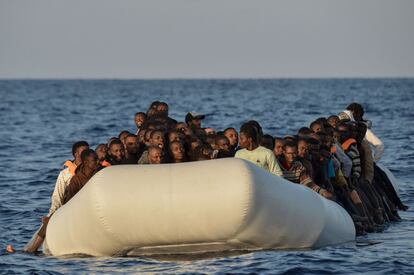 Migrantes y refugiados sentados en un bote de goma antes de ser rescatados en la costa libia. 