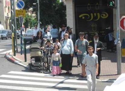 Familias ultraortodoxas judías transitan al lado de la tienda sólo para mujeres, en Bnei Bank.