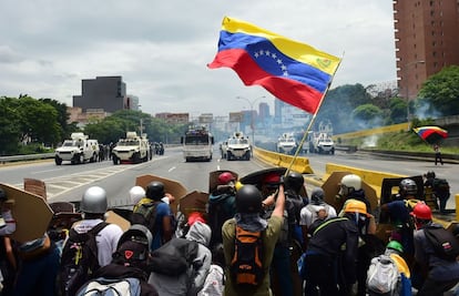 Un grupo de activistas contra Nicolás Maduro ondean una bandera venezolana durante los altercados con la policía.