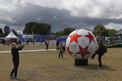 Dos aficionados se retratan con una réplica gigante del balón de la final de la 'Champions'.