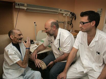 Josep Porta y Tomás Escolano escuchan las explicaciones que les da mediante signos el paciente Faustino Remón.