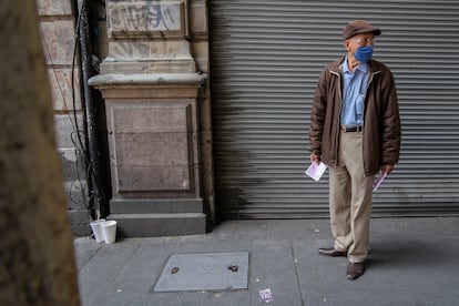 Gerardo Zamora, de 68 años, reparte información de una óptica en el centro de la Ciudad de México con una mascarilla durante la crisis del coronavirus.