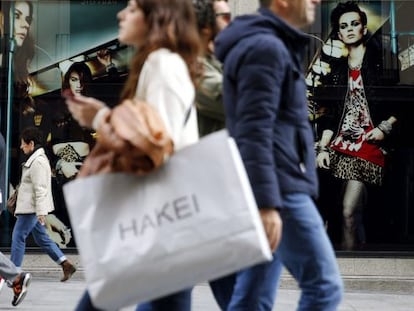 Varias personas pasan con bolsas de compras ante una de las tiendas de la c&eacute;ntrica calle Preciados de Madrid. EFE/Archivo