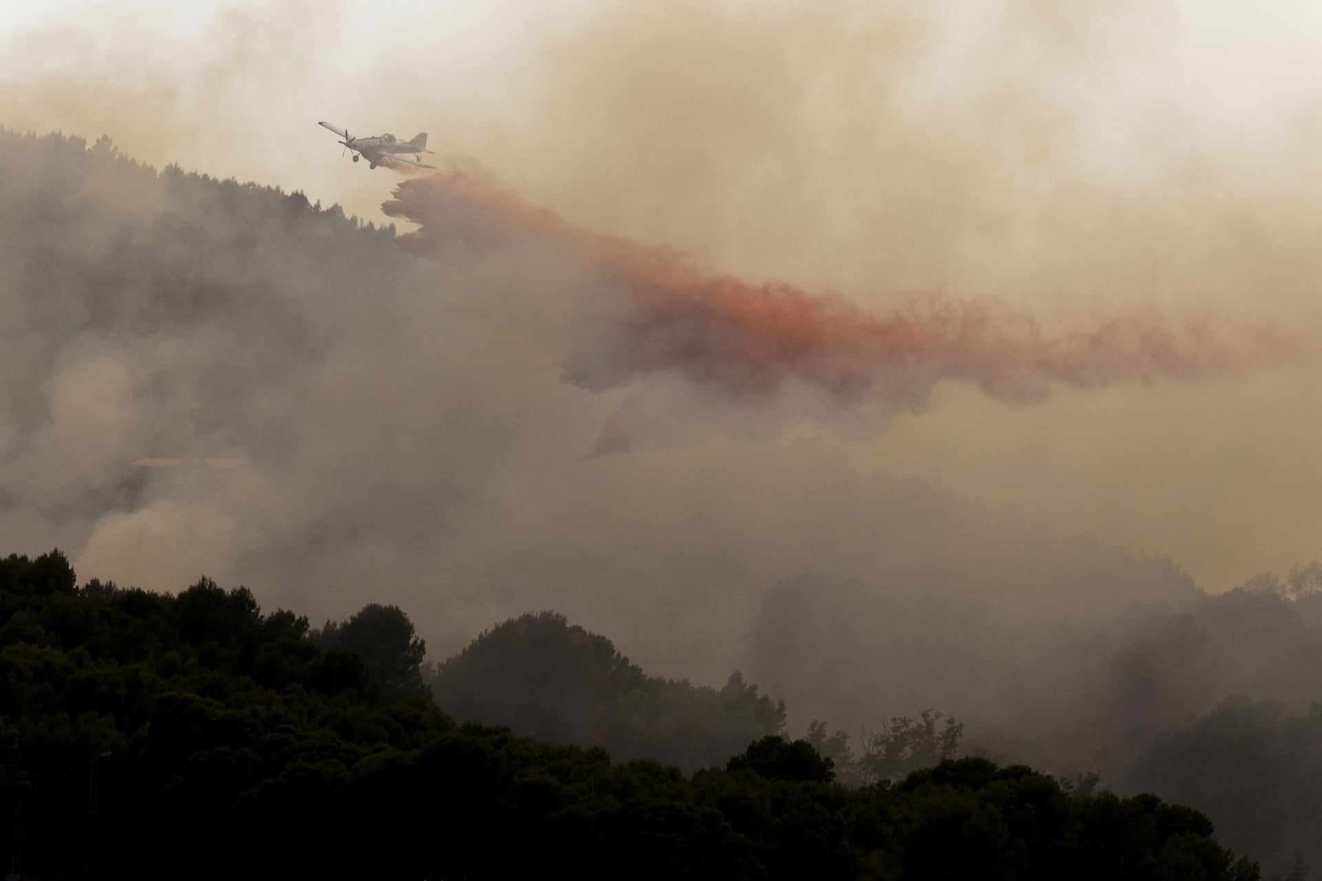 Un avión trabaja en la extición del fuego den Betxí, el lunes por la tarde.