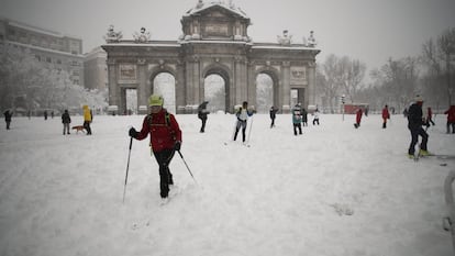 El temporal Filomena ha cubierto de blanco las calles y las carreteras, intransitables para los vehículos y conquistadas, seguramente por primera vez en la historia, por esquiadores, familias con sus trineos y tablas de snowboard, con palos de trekking, y por cientos de madrileños que han salido a pasear y a disfrutar de la nieve. En la imagen, esquiadores alrededor de la Puerta de Alcalá, en Madrid.