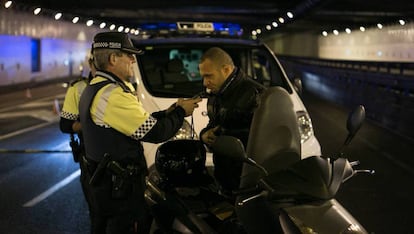 Un agente de la Guardia Urbana de Barcelona hace la prueba de alcoholemia a un motorista