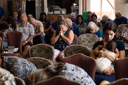 Algunos supervivientes de los incendios durante una oración en una iglesia de Maui (Hawái), el domingo 13 de agosto.