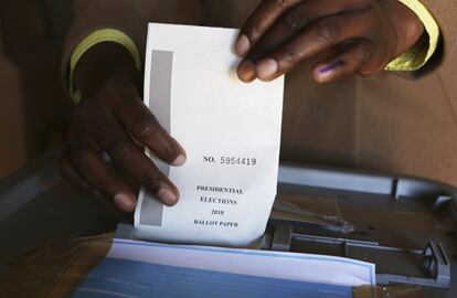 Un votante deposita su papeleta en una mesa electoral en Harare.