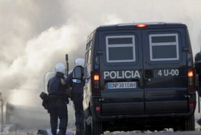 Agentes antidisturbios de la policía, ante una barricada incendiada en Melilla.