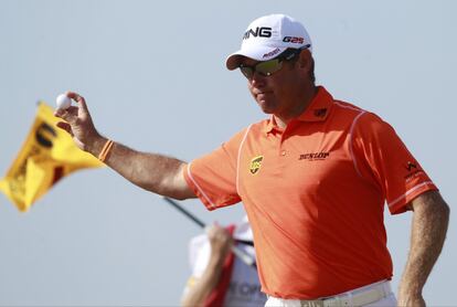 Lee Westwood saluda al público, con la bola en la mano, después de embocar en el sexto hoyo.