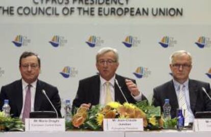 El presidente del eurogrupo, Jean-Claude Juncker (centro); el presidente del Banco Central Europeo, Mario Draghi (izda), y el comisario europeo de Asuntos Monetarios, Olli Rehn (dcha), ofrecen una rueda de prensa durante la reunión informal de ministros de Finanzas del Eurogrupo celebrada en Nicosi (Chipre) hoy.