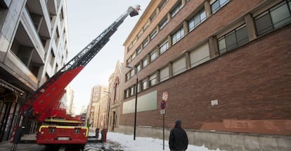 Los bomberos retiran esta mañana la nieve acumulada en el tejado de un edificio del centro de Vitoria.