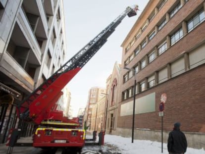 Los bomberos retiran esta mañana la nieve acumulada en el tejado de un edificio del centro de Vitoria.