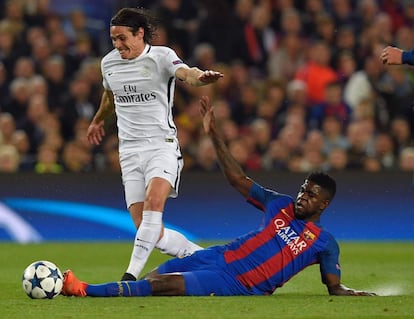 Samuel Umtiti (dreta), a terra, lluita per la pilota davant d'Edinson Cavani del PSG.