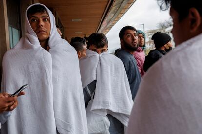 Migrantes esperan en una parada de Metro después de viajar en autobús desde Texas, en Wilmette (Illinois), en abril de 2024.