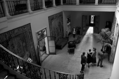 Vestíbulo del palacete de la calle de Muntaner, en una imagen de la película 'Blancanieves' rodada allí; las paredes vacías de cuadros están cubiertas por grandes tapices.