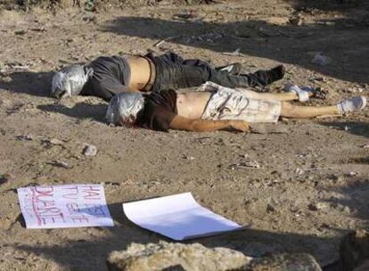 Los dos cuerpos yacen en el suelo junto a un cartel que delata la relación con el narcotráfico del crimen.