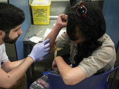 Un sanitari de la sala de venipunció Baluard de Barcelona supervisa el consum d'heroïna d'una usuària.