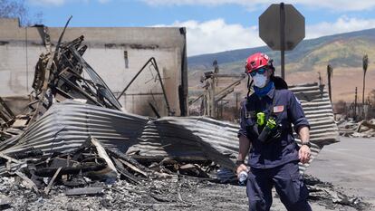 A member of a search-and-rescue team walks along a street, Saturday, Aug. 12, 2023, in Lahaina, Hawaii, following heavy damage caused by wildfires.