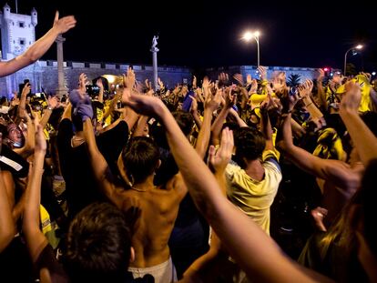 GRAF7091. CÁDIZ, 13/07/2020.- Pese a los llamamientos a la prudencia y la responsabilidad, cientos de aficionados cadistas han querido celebrar la subida a Primera División de su equipo en la fuente de las Puertas de Tierrra, hoy domingo en Cádiz, que estaba vallada para evitar esta aglomeración ante los brotes de coronavirus que se están produciendo en todo el país. EFE/Román Ríos