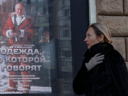 Una mujer camina delante de una imagen de Vladímir Putin, en Moscú, este lunes.