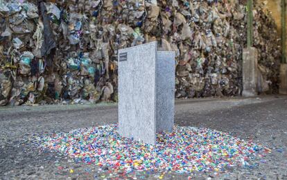 Al fondo, botellas para reciclar en la planta de Eko-REC. En el centro, una funda de portátil sobre trozos de plástico reciclado.