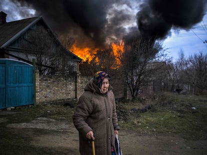 Una anciana ante un edificio en llamas tras un ataque de artillería ruso, este miércoles en Konstantinovka​, en la provincia ucrania de Donetsk.