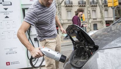 Un conductor recarga el coche el&eacute;ctrico en Barcelona. 