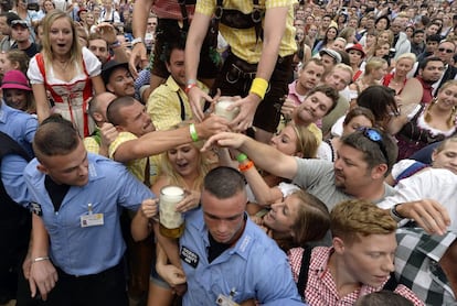 Este año se ha contado con la asistencia de 6,3 millones de visitantes de todas las nacionalidades del mundo. En la imagen, los visitantes cogen una de las primeras jarras de cerveza que se ofrecen al público gratis en la inauguración del festival, el 20 de septiembre de 2014.