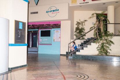Una mujer sentada en los pasillos vacíos del centro comercial.