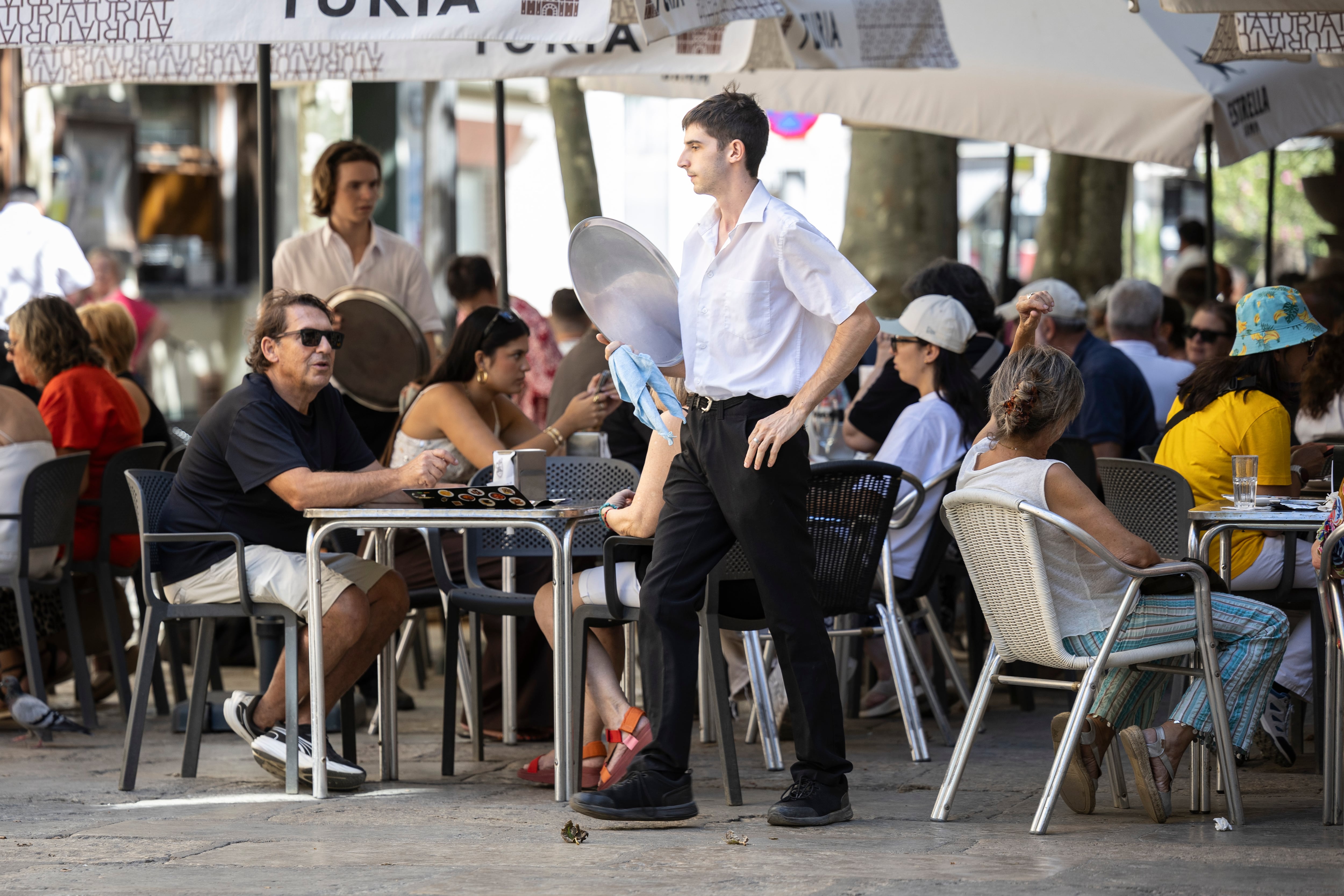 Un camarero atiende a los clientes en un restaurante de Blanes (Girona).