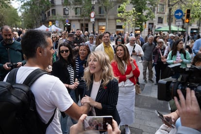 La vicepresidenta segunda y ministra de Trabajo, Yolanda Díaz, saluda a un joven durante su paseo por las parada de Sant Jordi.